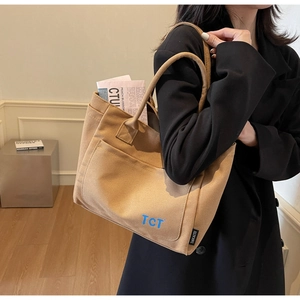 Detail view of khaki canvas tote bag with blue TCT print and large capacity pocket