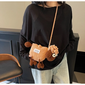 Detail of handmade knit sheep crossbody bag featuring brown wool texture and long strap