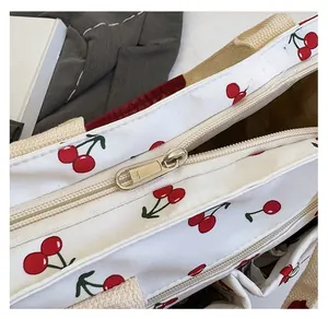 Detailed macro view showing a high-quality YKK metal zipper on a cherry print tote bag