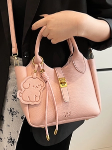 Sac seau en cuir rose grainé avec pendentif chien et fermoir doré tournant