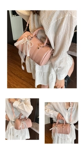 Detail view of pink Boston bag featuring delicate white lace bows and artificial pearls