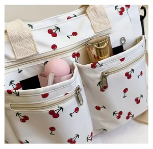 Detail view of canvas tote bag front pockets storing a folding umbrella and water bottle