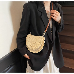 Détail du sac bandoulière tissé beige avec texture pétale et sangle en cuir