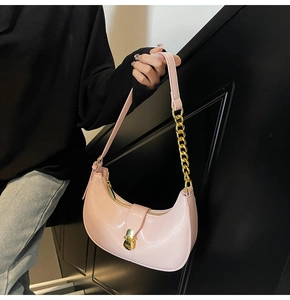 Pink crescent underarm bag with glossy finish and gold metal chain strap detail