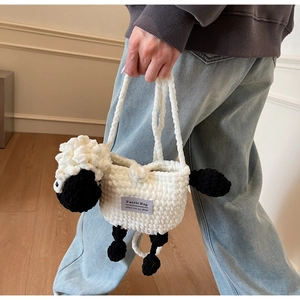 Detail of handmade crocheted lamb-shaped bag with black and white knit texture