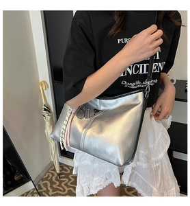 Close-up of silver metallic hobo bag with triangle logo and racket charm detail