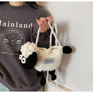 Detailed close-up of handmade sheep-shaped knit bag texture with Faerie Bag label