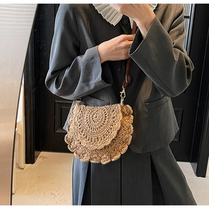 Détail d'un sac bandoulière en paille tressée avec bords festonnés et fine lanière