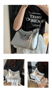 Detailed macro view of the silver metallic hobo bag with iconic triangle logo plaque