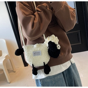 Close-up of sheep-shaped knitted crossbody bag with Faerie Bag brand label detail