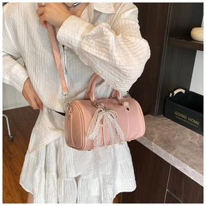 Detail of pink cylindrical bowling bag with lace bow and pearl pendant decoration