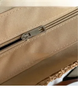 Close-up of smooth silver metal zipper pull and durable canvas texture on a tote bag