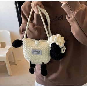 Detail of a handmade crochet cartoon sheep shoulder bag with fuzzy knit texture