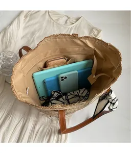 Top view of large straw tote bag showing spacious interior with tablet and phone