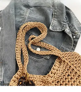 Gros plan sur la bandoulière tressée épaisse et la texture du sac fourre-tout kaki