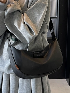 Minimalist black crescent crossbody bag with adjustable wide strap for daily travel use