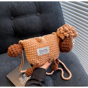 Detail of handmade crochet sheep bag with brown knit texture and white brand label on front