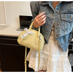 Detail of light yellow lychee pattern leather bowling bag with silk bow and 'FOR YOU' ribbon