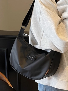 Minimalist black nylon crescent crossbody bag with adjustable wide strap for daily commute