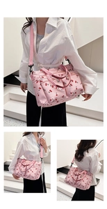 Detailed view of pink tote bag with cherry print featuring adjustable shoulder strap and pockets