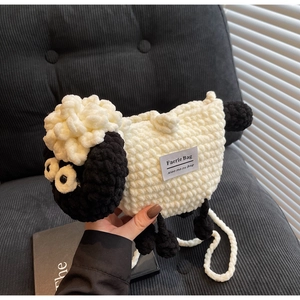 Detailed macro view of handmade wool knit sheep bag with Faerie Bag brand label