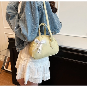 Creamy yellow bowling bag with a ribbon bow detail and a soft pebbled leather texture