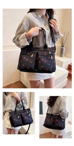 Detail view of lightweight nylon tote bag with red cherry prints and zip pockets