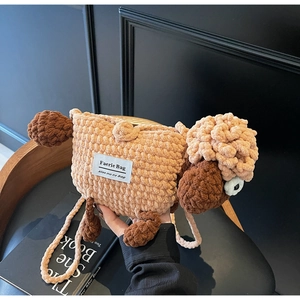 Detail of a handmade brown sheep knit crossbody bag with woven texture and a strap