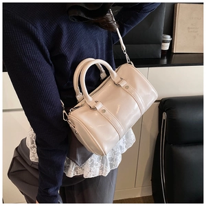 Detail view of cream Boston bag in smooth faux leather with silver metal hardware