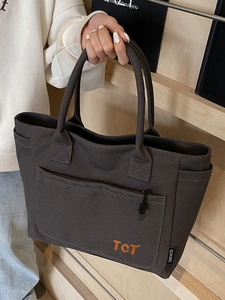 Minimalist dark gray canvas tote bag with large zipper pocket and orange TCT lettering