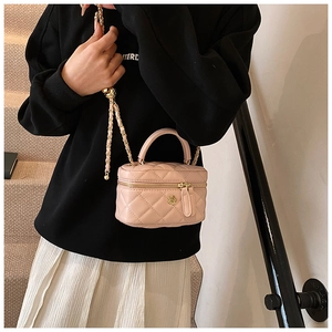 Detailed close-up of pink quilted crossbody bag with gold floral buckle and chain strap