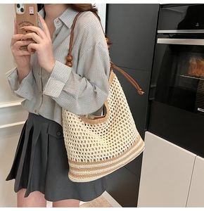 Dettaglio borsa tote intrecciata a mano con perle in legno e coulisse in pelle vintage