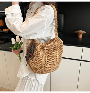 Vue détaillée du sac cabas tissé beige avec charme de lettre marron en intérieur
