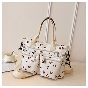 Detail of canvas tote bag showing cherry print and multiple functional front pockets