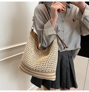 Dettaglio della borsa tote all'uncinetto con trama beige e fondo a righe scure
