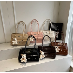 Selection of six stylish glossy leather shoulder bags in various colors with bear charms