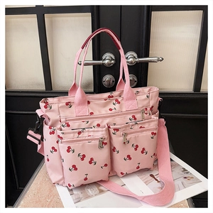 Detailed view of pink tote bag with cherry prints featuring multiple functional pockets