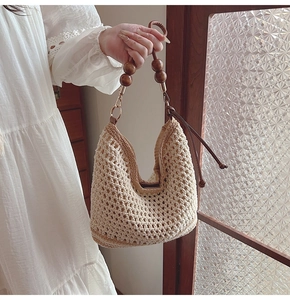 Dettaglio della borsa tote in maglia traforata con perline in legno e nappe in pelle
