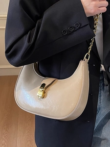 Minimalist beige dumpling shoulder bag with glossy patent leather and gold chain