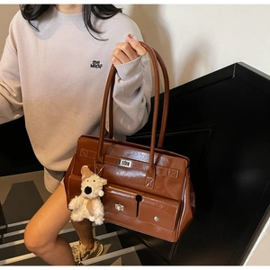 Detail of vintage brown leather underarm bag with double front pockets and metal buckles