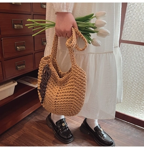 Détail du sac cabas tissé main avec breloque lettre marron et texture rustique