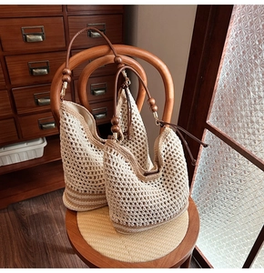Dettaglio di borse tote in maglia color crema con perline in legno e manici in cuoio