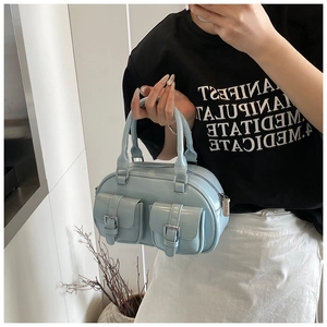 Detailed view of light blue patent leather bowling bag with double pockets and dual handles