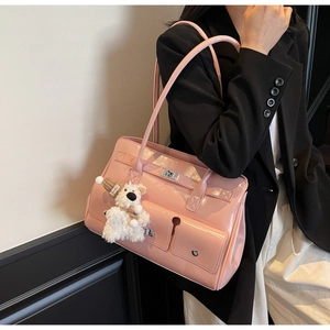 Close-up of pink patent leather tote bag featuring a metal twist lock and cute bear charm