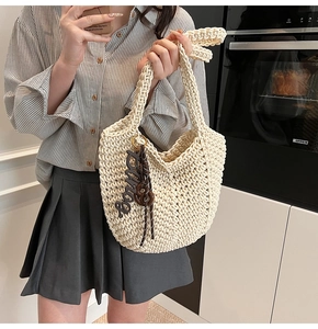 Détail du sac cabas crochet crème fait main avec texture tricotée épaisse et breloque
