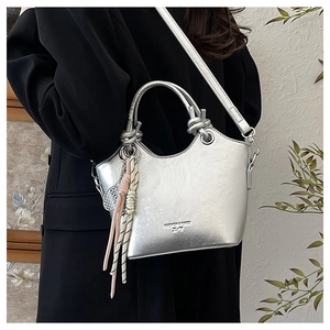 Dettaglio della borsa tote argento metallizzato con manici a nodo e pendente in corda