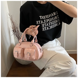 Detail of pink leather bowling bag with twin front pockets and metal buckle hardware