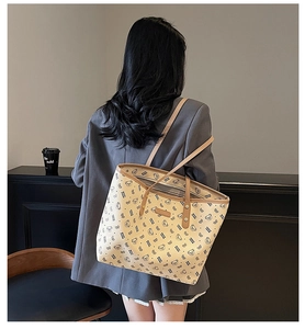 Dettaglio della grande borsa tote beige con stampa orsetto e manici in pelle marrone