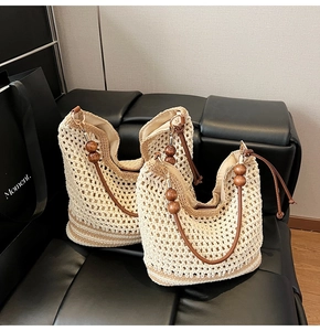Dettaglio della borsa tote tessuta con perle di legno scuro e base a righe marroni