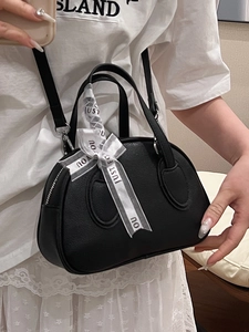 Black pebbled leather bowling bag with white mesh bow and detachable shoulder strap